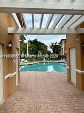 Outdoor swimming pool with surrounding architecture and a paved walkway.