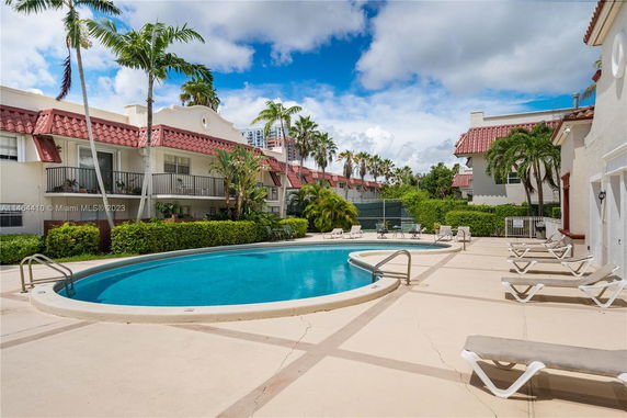 Outdoor area with a swimming pool and surrounding lounge chairs.