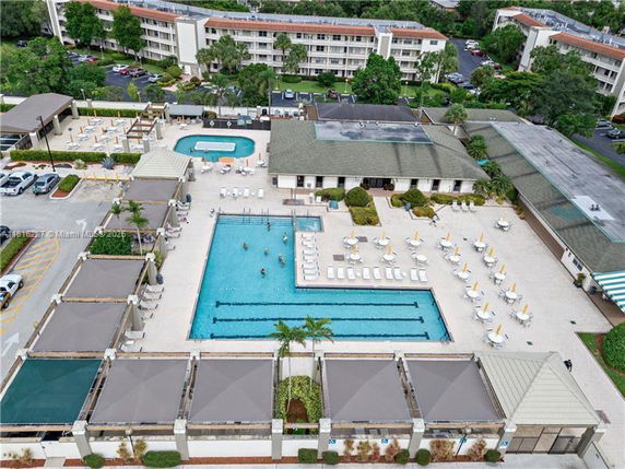 Aerial view of a recreational area with a large swimming pool and surrounding lounge chairs.