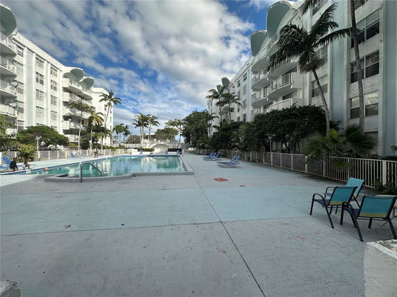 Outdoor swimming pool area with surrounding apartment buildings.