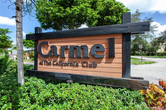 Signage for Carmel at The California Club surrounded by trees and greenery.