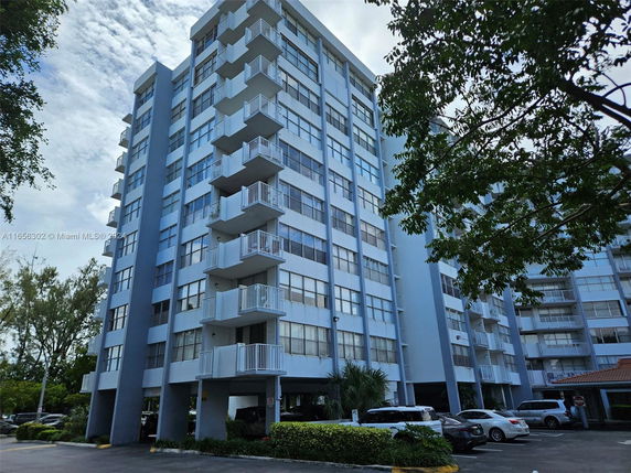 Front view of a multi-story apartment building with balconies.