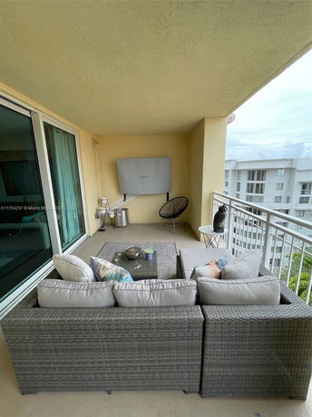 Balcony view with outdoor seating overlooking surrounding buildings.