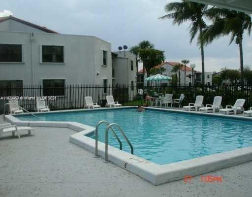 Outdoor swimming pool area with surrounding apartment buildings.