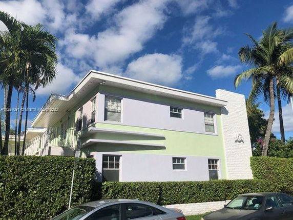Front view of a two-story building with a pastel color scheme and a flat roof.