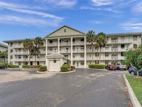Front view of a multi-story apartment building with balconies and columns.