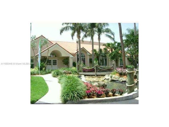 Front view of a single-story house with a landscaped garden and pond.