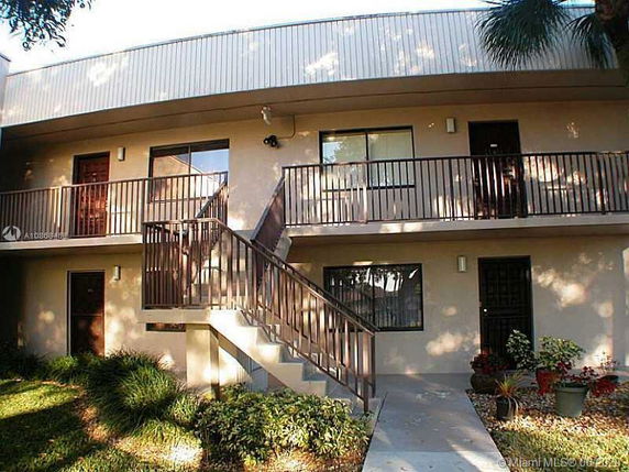 Front view of a two-story residential building with stairs and balconies.
