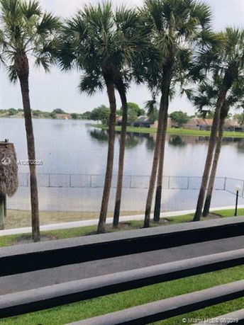 View of a lake and palm trees from a building.