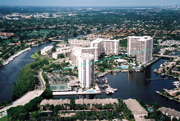 Aerial view of tall residential buildings surrounded by waterways and greenery.
