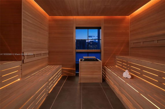 Interior view of a modern sauna room with wooden benches and soft lighting.