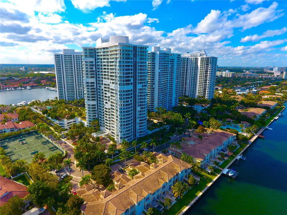 Aerial view of multiple high-rise buildings near a waterway in a residential area.