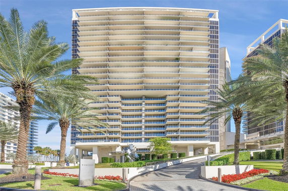 Front view of a modern multi-story building with balconies.