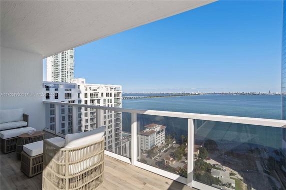 Balcony with a panoramic view of the ocean and city skyline in the background.
