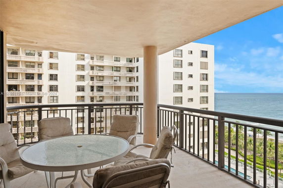 Balcony view overlooking nearby buildings and ocean.