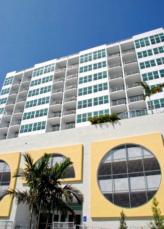 Front view of a multi-story building with large circular designs and balconies.