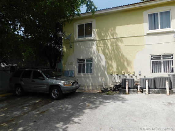 Outdoor parking area next to a two-story building with a parked SUV.