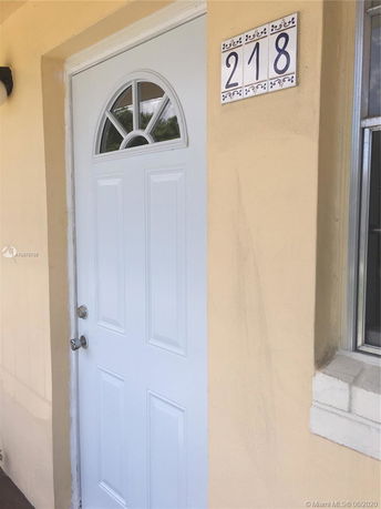Front view of a house entrance with a white door and house number 218.