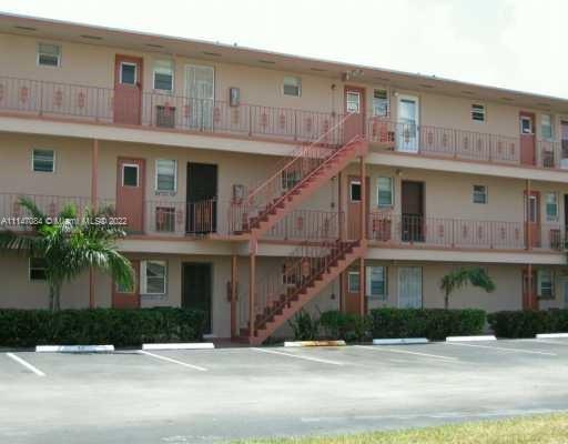 Front view of a multi-story apartment building with external staircases.