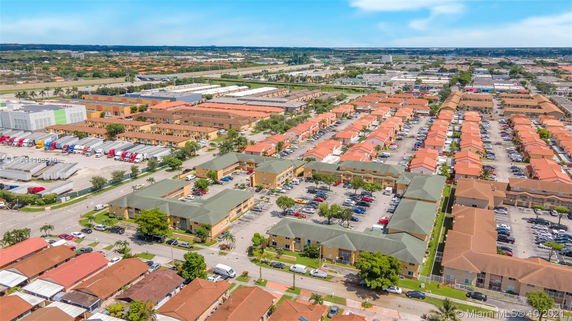 Aerial view of a residential and commercial area with rows of houses and industrial buildings.