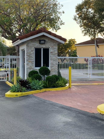 Front view of a small guardhouse near a gated entrance.