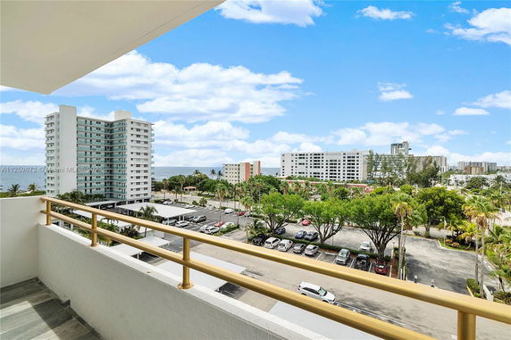 View from a building showing nearby high-rise structures and a distant ocean.