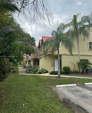 Front view of a multi-story building with a red roof and beige exterior.