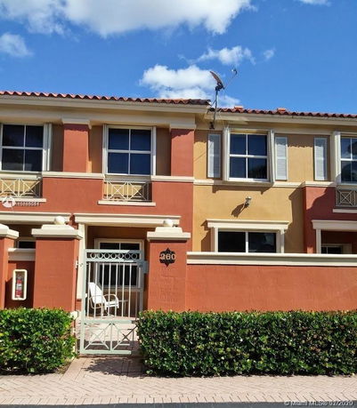 Front view of a two-story house with a gated entry and decorative windows.