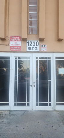 Front view of a building entrance with glass double doors and signage.