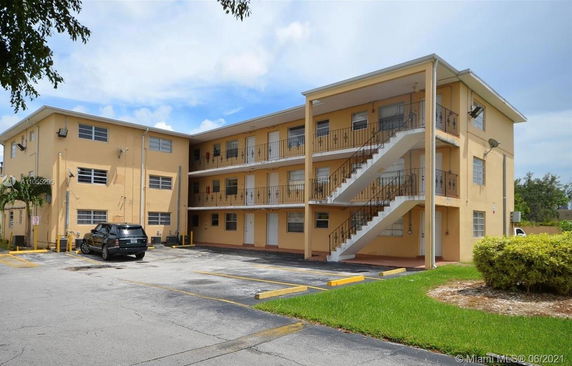 Front view of a three-story apartment building with external staircases.