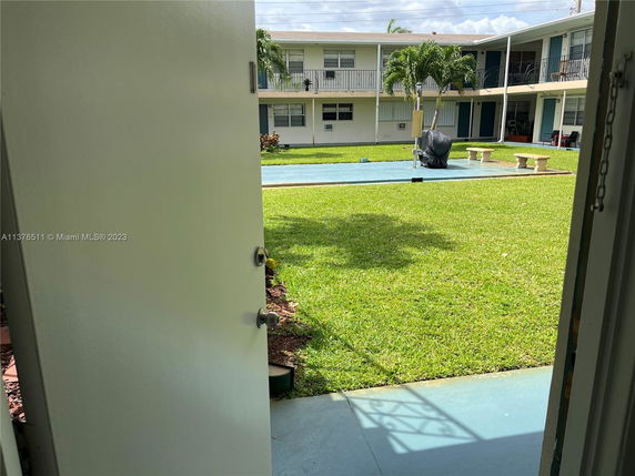 View from a door showing a courtyard in a multi-story residential building.