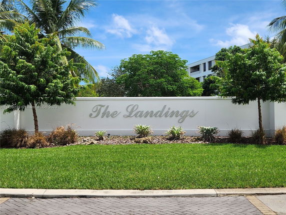 Front view of a white entrance wall with 'The Landings' sign.