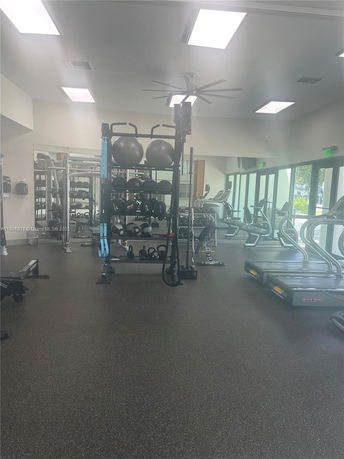 Interior view of a gym with exercise equipment and large windows.