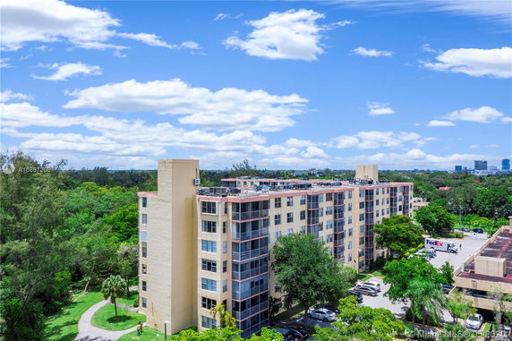 Building with several floors featuring a flat rooftop with air conditioning units.