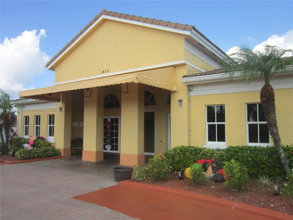 Front view of a building with yellow exterior and awning.