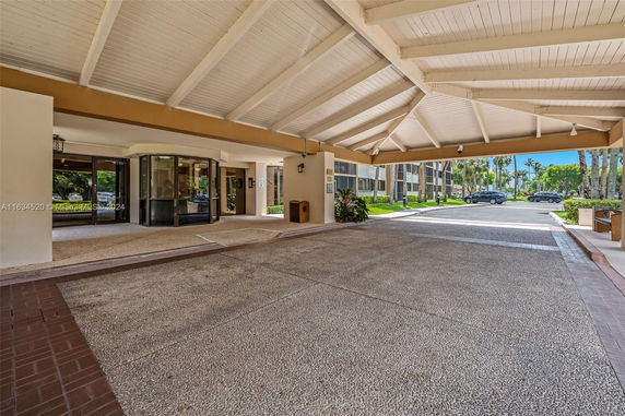 Covered entrance area of a building with large glass doors.