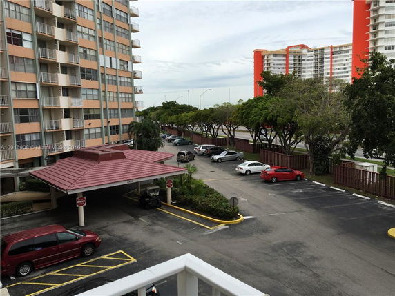 View of the surrounding area including a multi-story building and a parking lot.