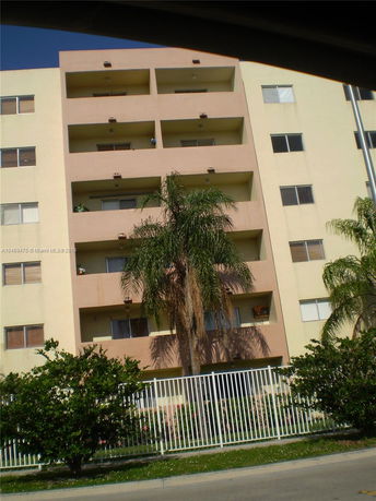 Front view of a multi-story apartment building with balconies.