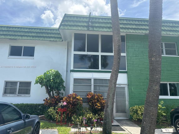 Front view of a two-story building with a green and white exterior.