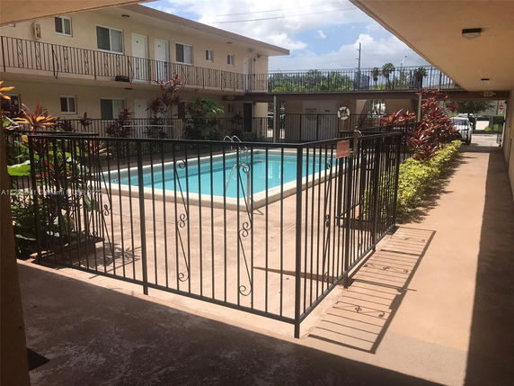 Swimming pool area in a multi-story residential building courtyard.