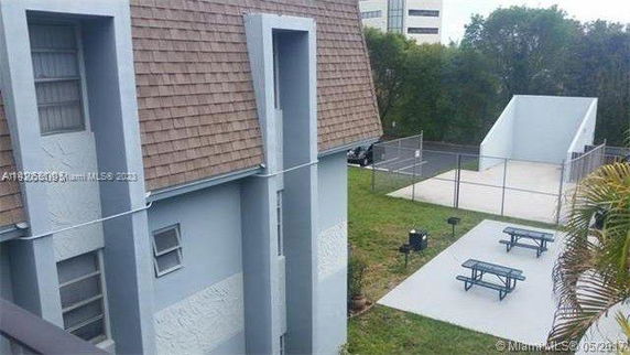 View of a building with sloped roof and adjacent outdoor area with picnic tables.