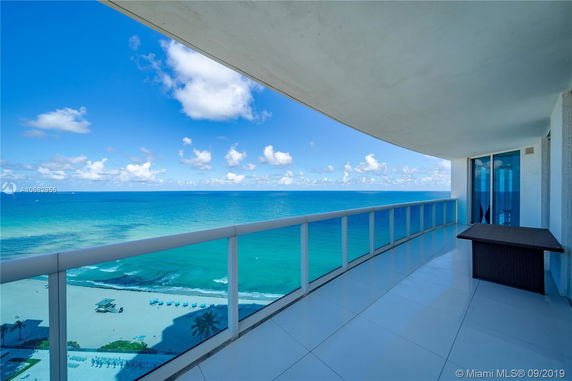 Panoramic view of the ocean from a high-rise balcony.