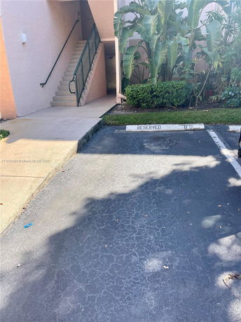 Outdoor reserved parking space near a stairway entrance.