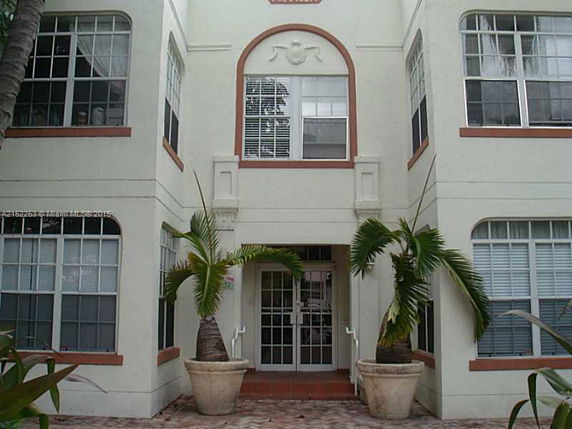Front view of a multi-story building with arched windows and decorative elements.