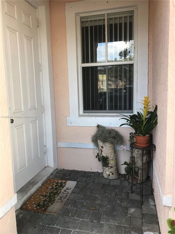 Entrance of a house with a door, window, and welcome mat.