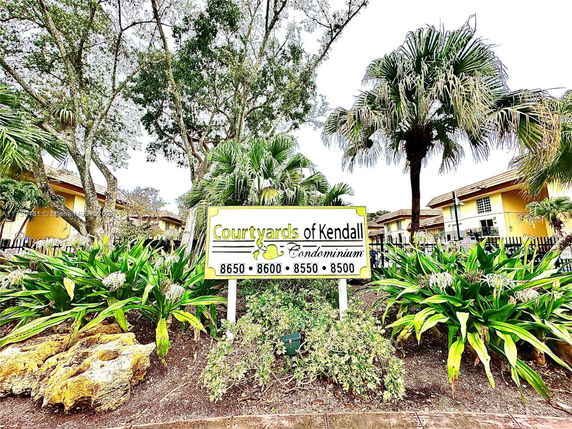 Front view of condominium complex with sign indicating 'Courtyards of Kendall'.