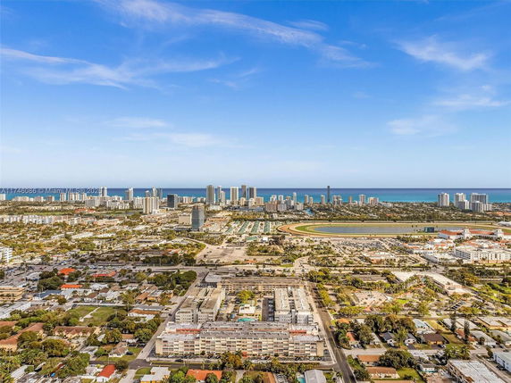 Wide-angle view of a cityscape with high-rise buildings and a coastal shoreline in the distance.