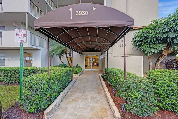 Entrance view of a multi-story building with an awning and walkway.
