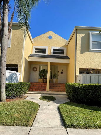 Front view of a two-story house with a triangular roof and double doors.