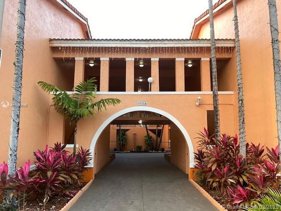 Front view of a building with an archway entrance and columns.